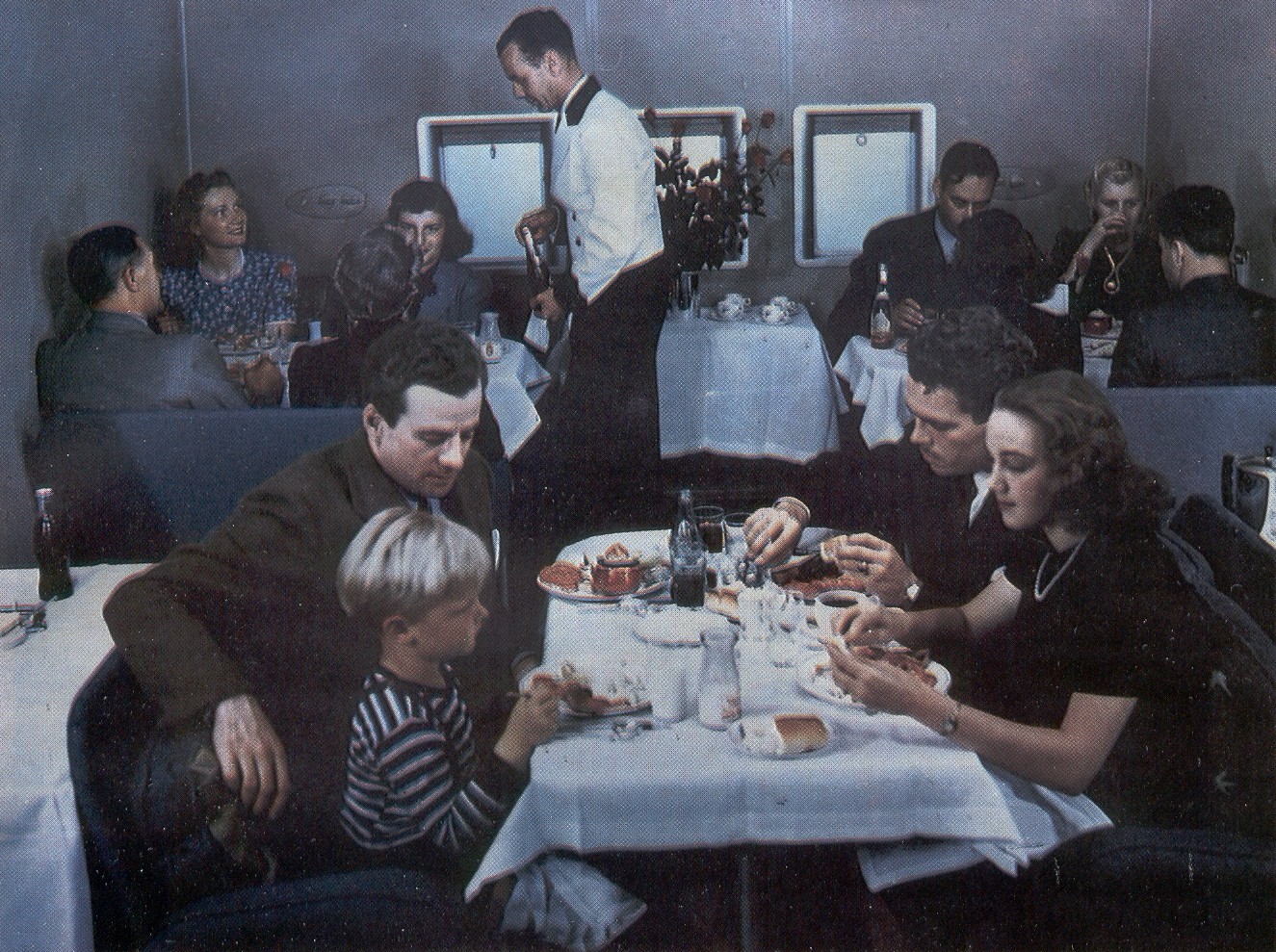 1939 Passengers dinning in the main lounge of a Boeing B314.  The all first class service offered multi-course hot meals with table linens and fine china.